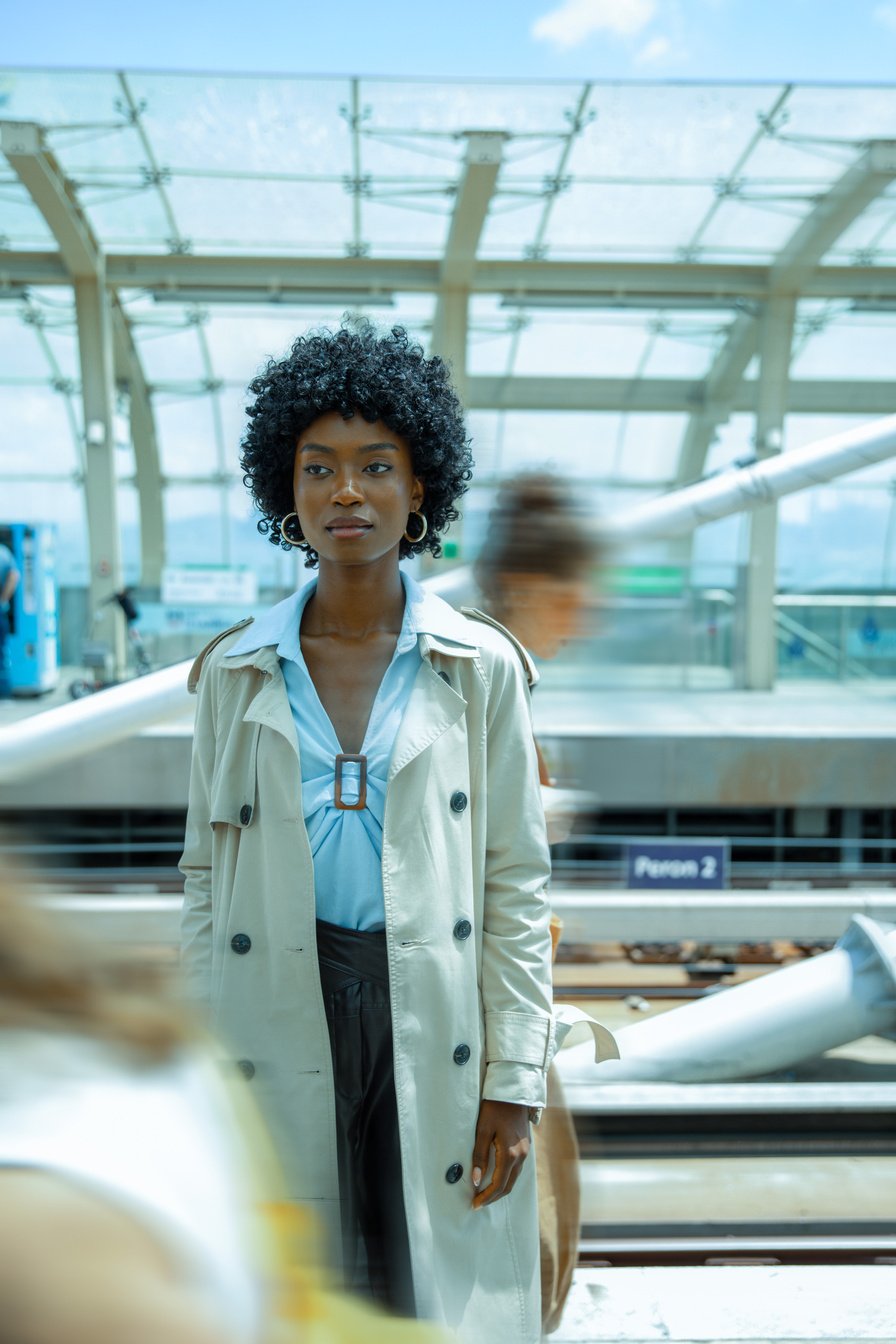 Woman Standing in a Busy Train Station